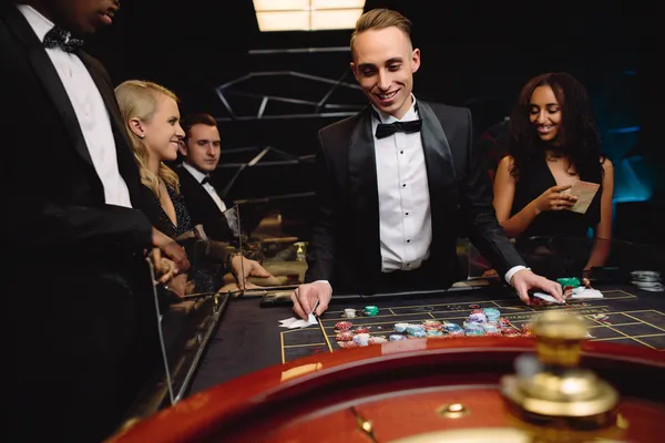 A woman in a luxurious green gown next to an ornate roulette wheel, capturing the upscale casino mood of BLITZ.
